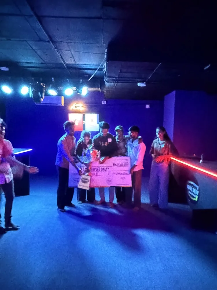 A big group with the giant cheque in the arena