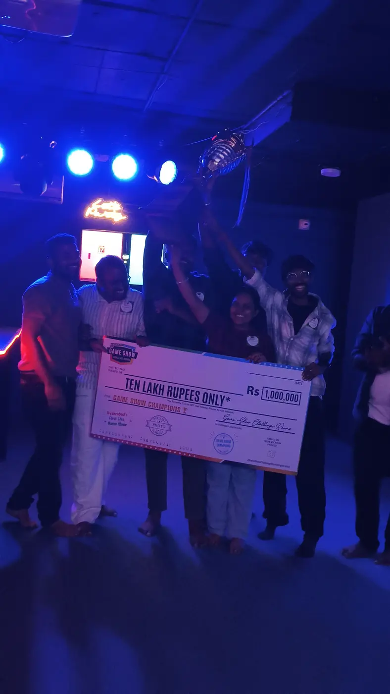 A team lifting the trophy under the arena lights