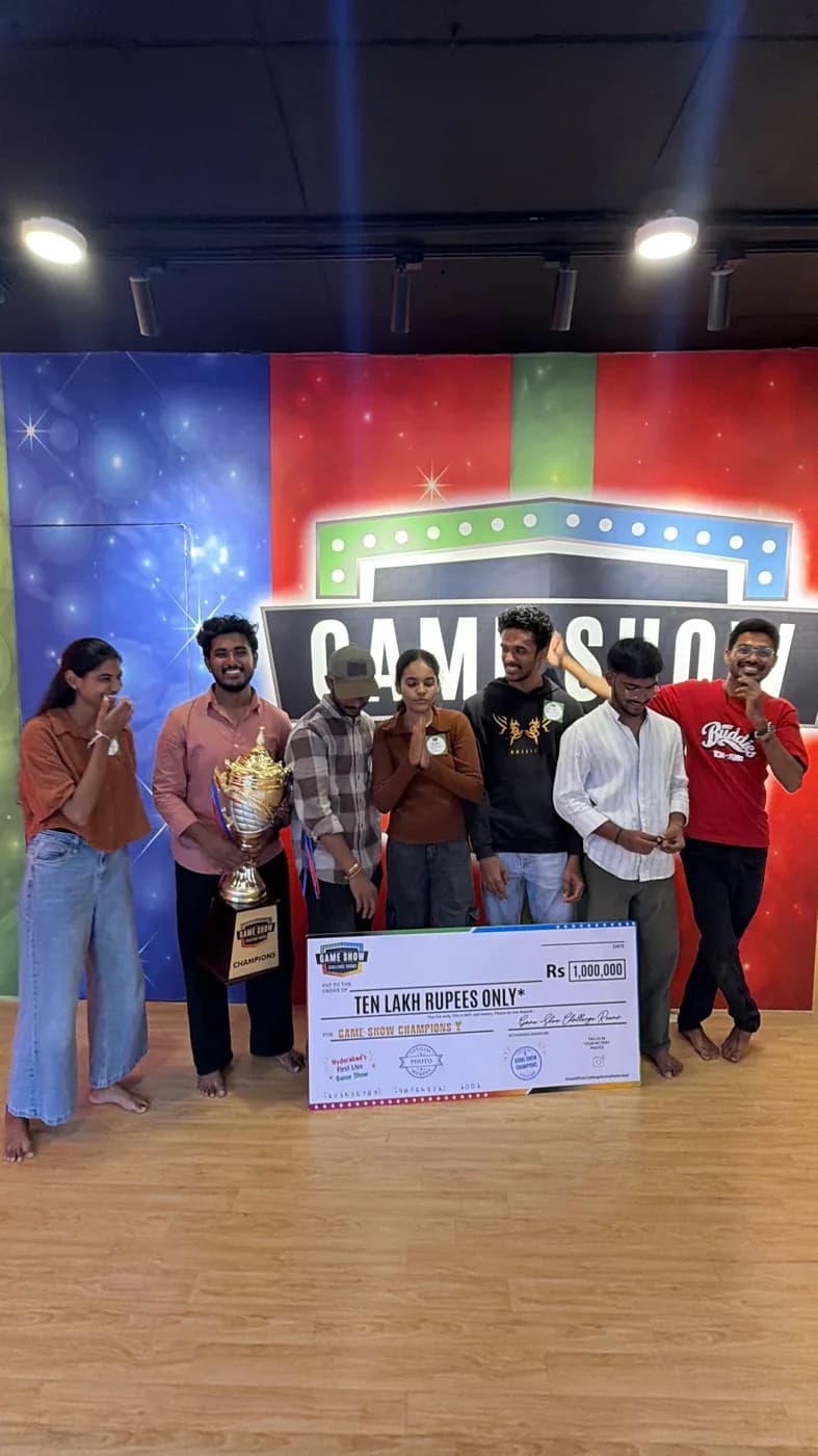 Champions holding the trophy and giant cheque in front of the logo wall