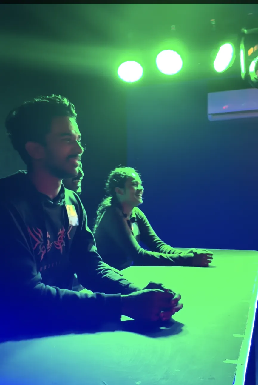 Two players at the desk under green lights