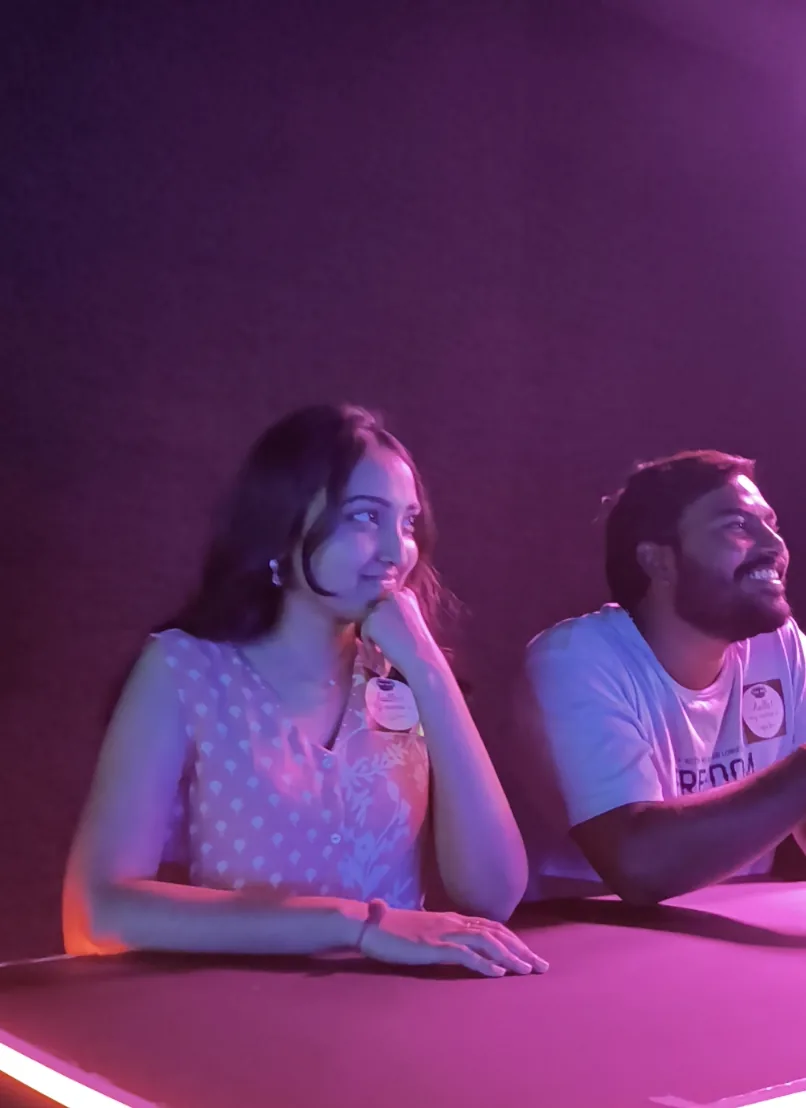 Two players thinking hard at the desk under pink lights