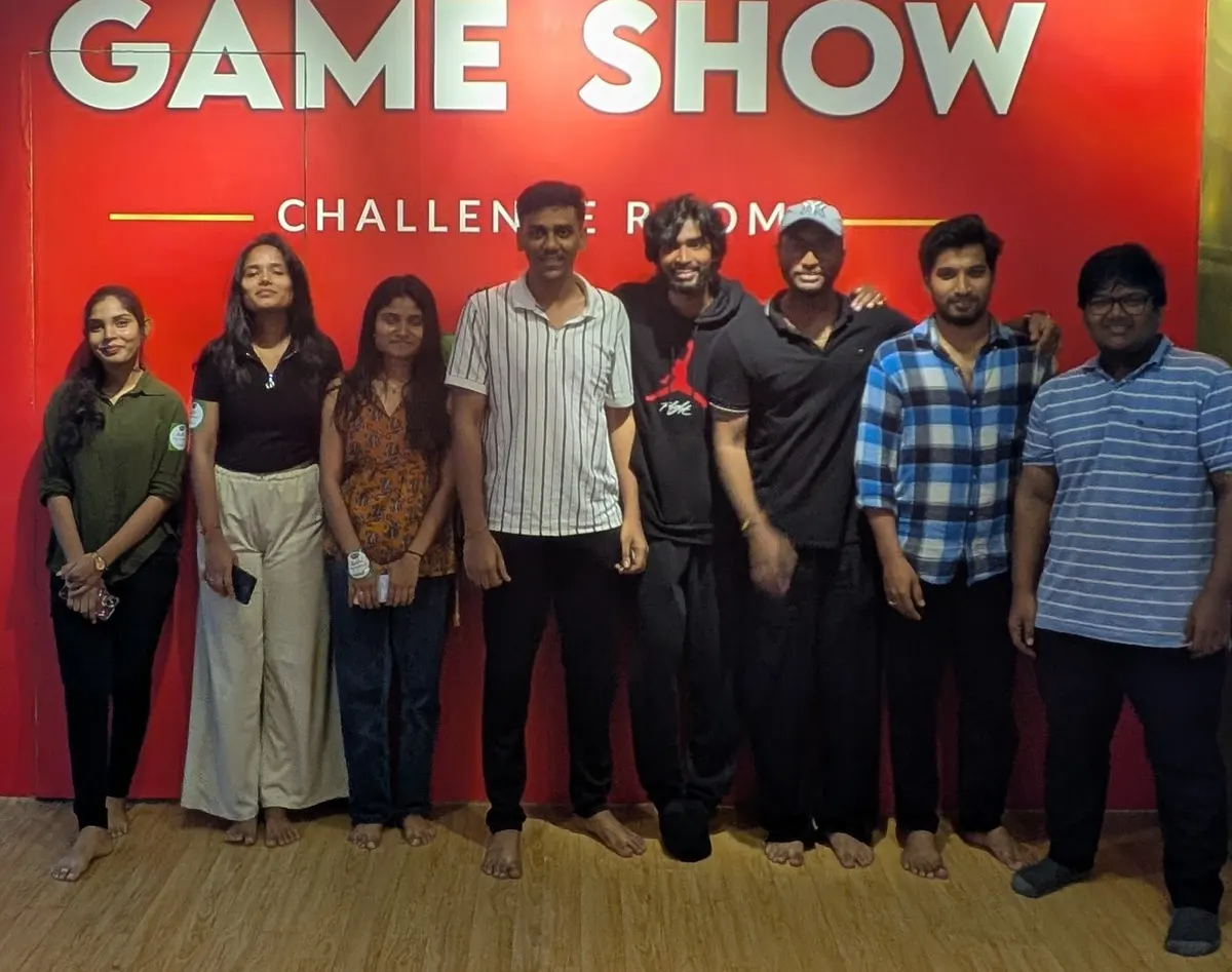 A group in front of the red Game Show wall