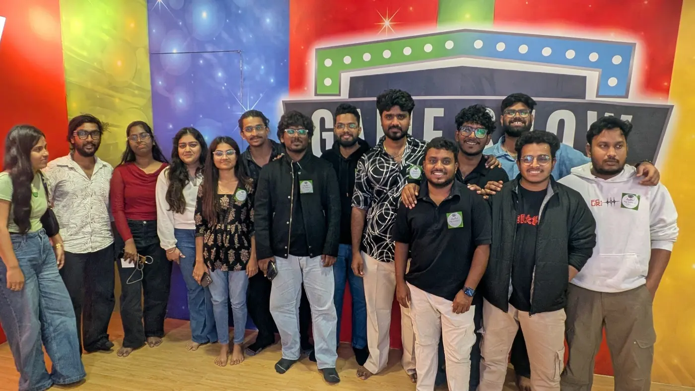 A group of friends in front of the Game Show logo wall