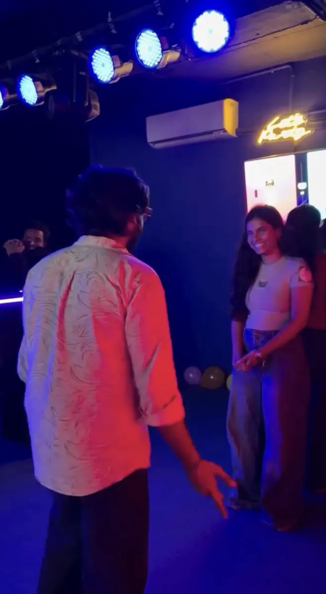 The host facing a smiling player on the arena floor