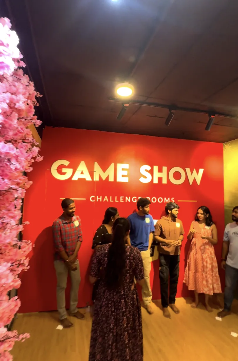 A group lined up in front of the red Game Show wall