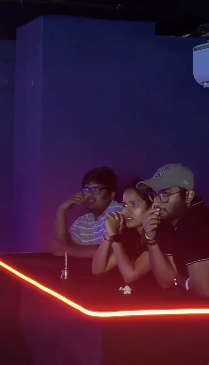 A team watching the board nervously from the red-lit desk
