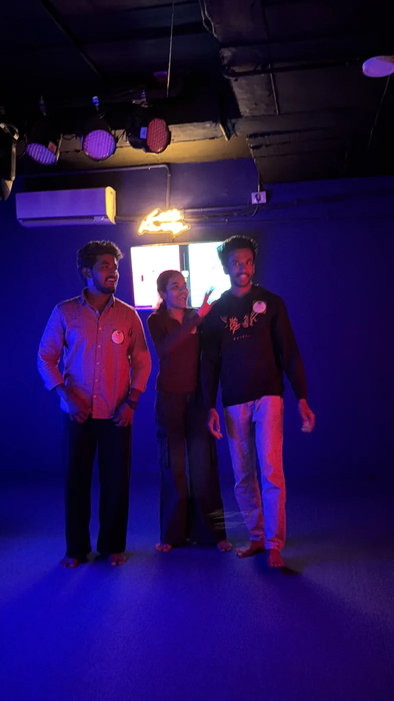 Three players celebrating under blue lights